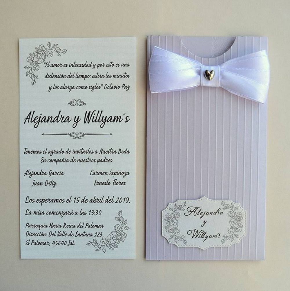 Invitación de boda con diseño elegante en color lila y crema, sobre con textura de líneas verticales decorado con un moño de satén blanco, dije de corazón y etiqueta personalizada, ideal para eventos nupciales.