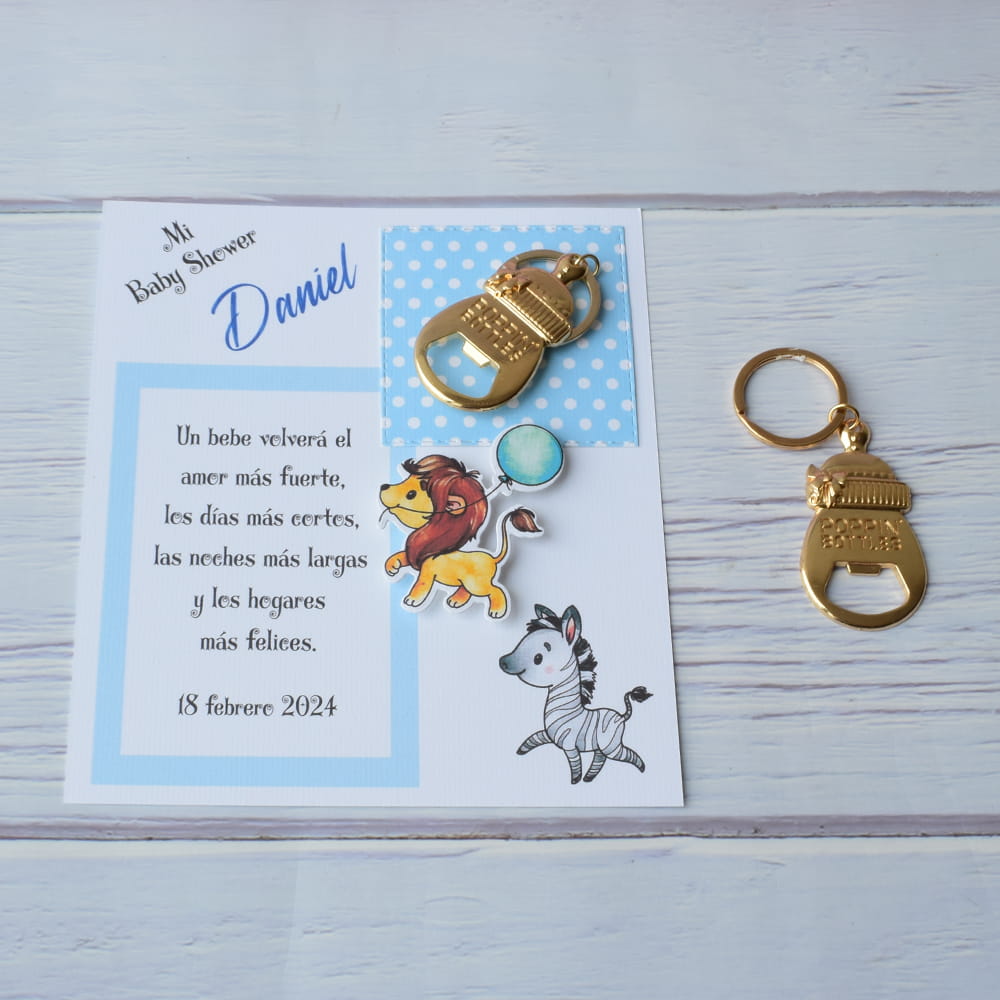 Recuerdo de baby shower para niño con destapador dorado en forma de biberón y tarjeta temática de safari.