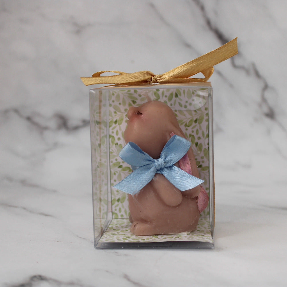 Vela artesanal en forma de conejo para baby shower o bautizo, presentada en caja decorada con listón y etiqueta personalizada.