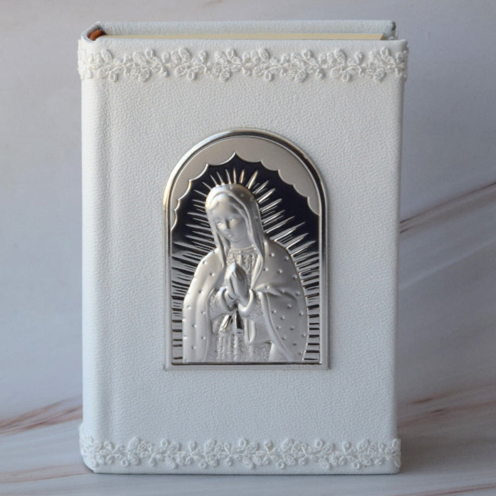 Biblia forrada en piel blanca, con placa italiana de la Virgen de Guadalupe.