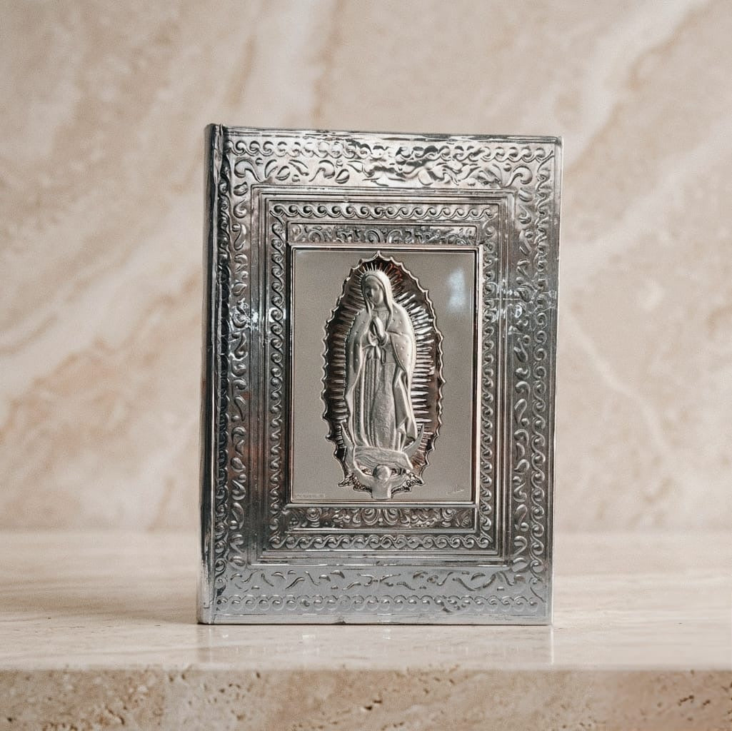 Biblia ceremonial con cubierta ornamentada en plata italiana y diseño repujado. 
