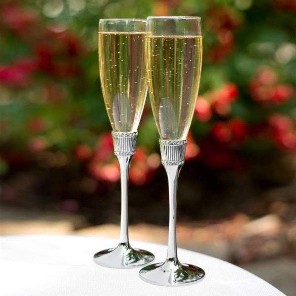 Pareja de copas para brindis de novios con tallos metálicos plateados y anillo decorativo con cristales, flautas de cristal elegantes para bodas y recepciones.