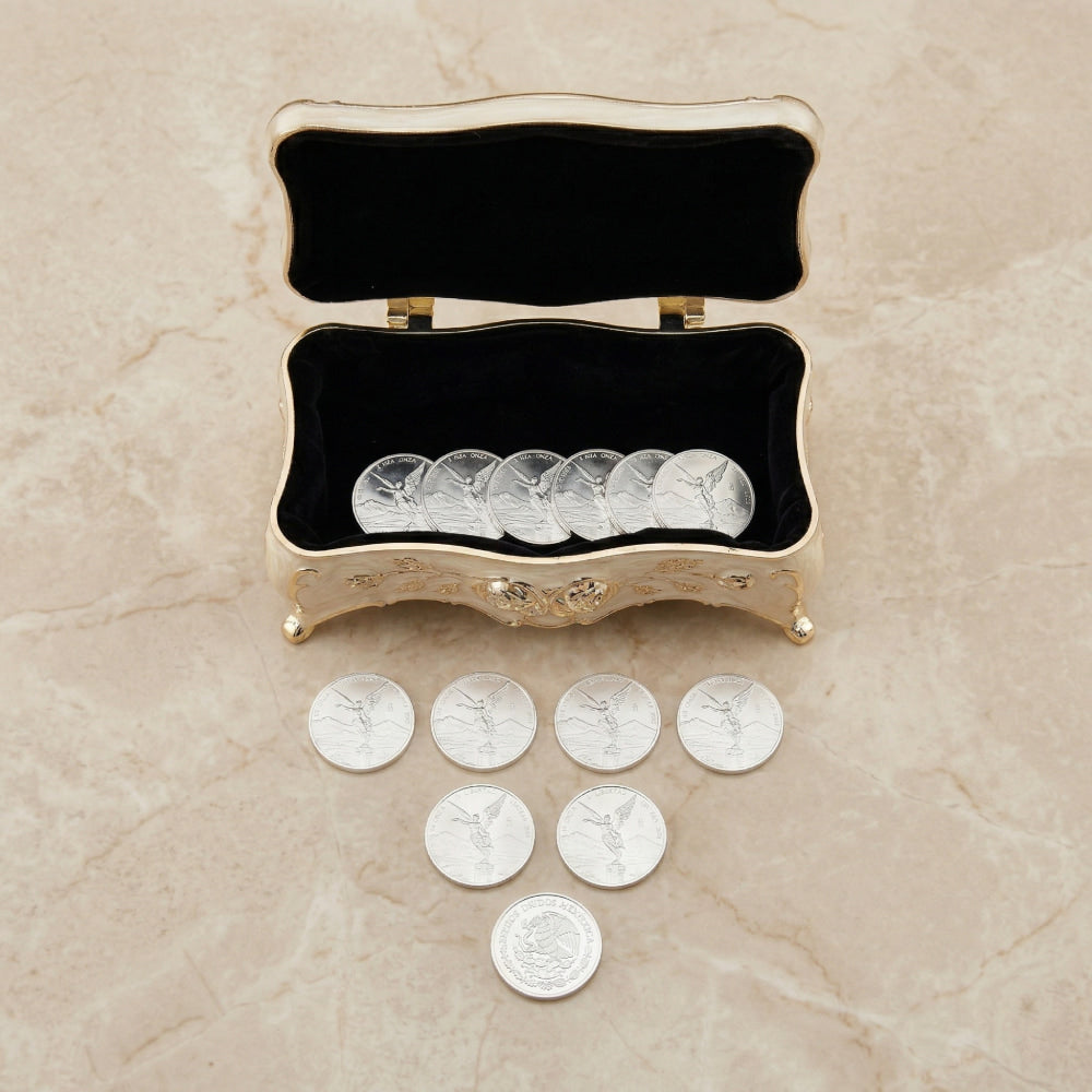 Arras de boda con diseño de Centenario en plata, presentadas en cofre de nácar con interior de terciopelo negro.