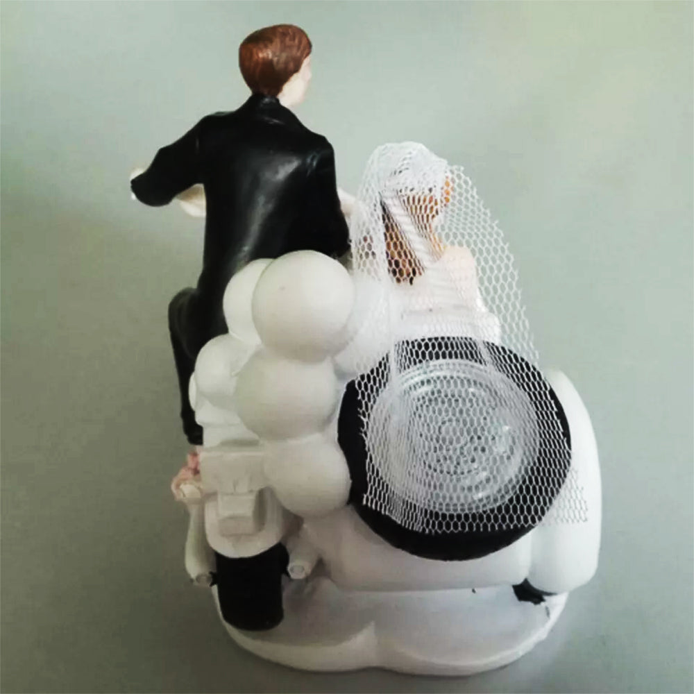 Figura para pastel de bodas con pareja de novios en motocicleta sobre fondo blanco.