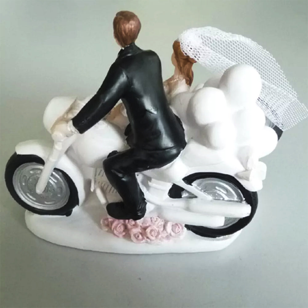 Figura para pastel de bodas con pareja de novios en motocicleta sobre fondo blanco.