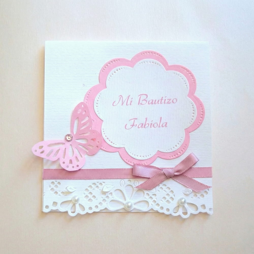 Tarjeta de invitación o recuerdo para bautizo en color blanco y rosa, decorada con una mariposa troquelada, moño de listón y detalles de corte láser en la parte inferior.