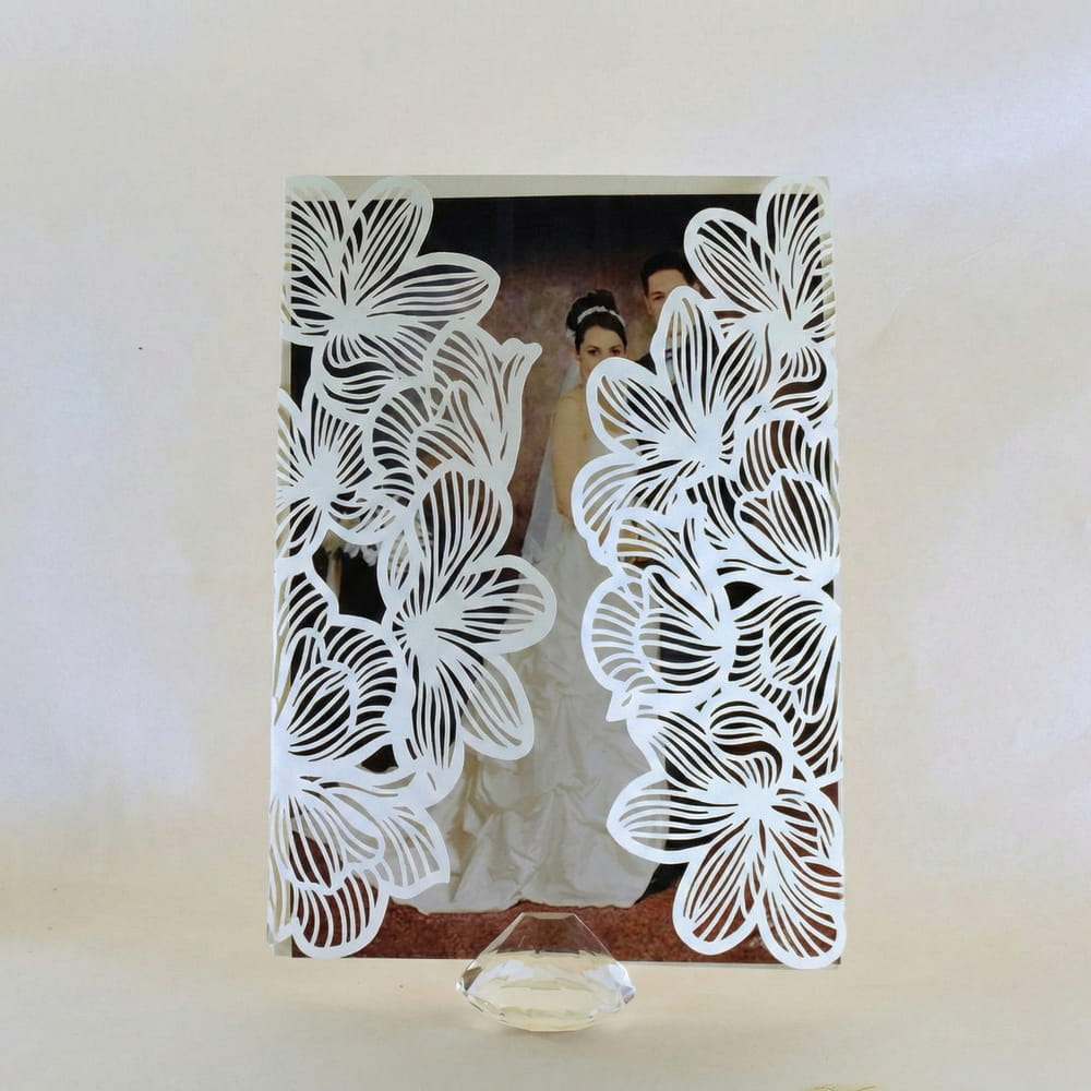 Invitación de boda con fotografía personalizada de los novios y elegante corte láser de flores en color blanco, ideal para eventos nupciales.