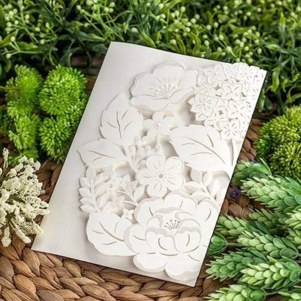 Invitación de boda con elegante diseño de corte láser floral en color blanco marfil, papelería fina y sofisticada para eventos sociales.