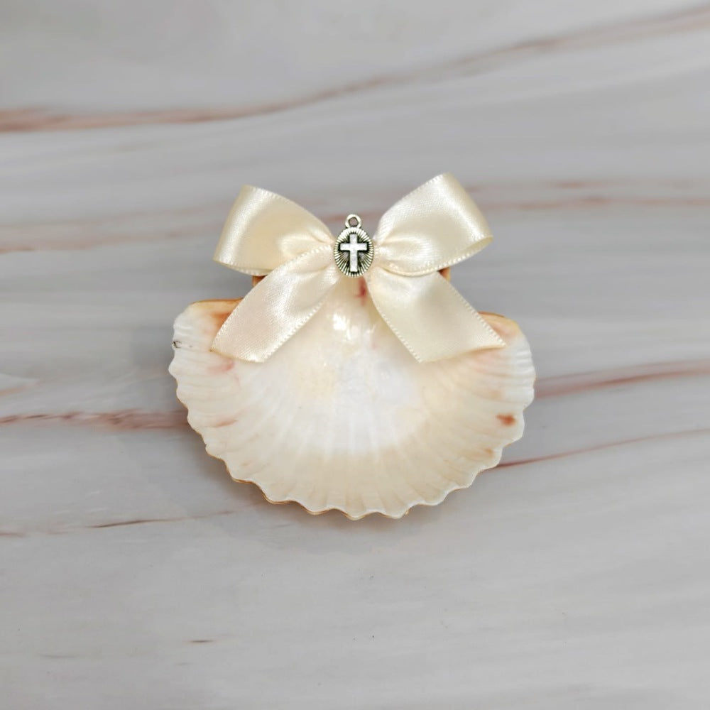 Conchita natural para bautizo con moño blanco y medalla de la Virgen de Guadalupe sobre mármol.