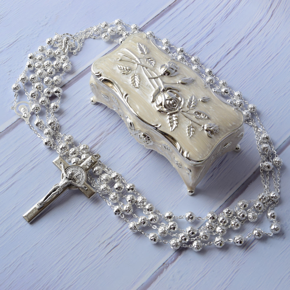 Kit de lazo Rose Silver con cruz artesanal nacarada y cuentas brillantes dentro de estuche plateado.