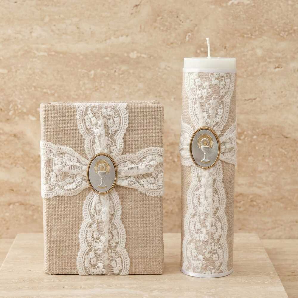 Kit de Primera Comunión compuesto por una biblia y un cirio. Ambos están forrados en tela de yute rústica, decorados con encaje blanco y un medallón central con la figura de un cáliz.