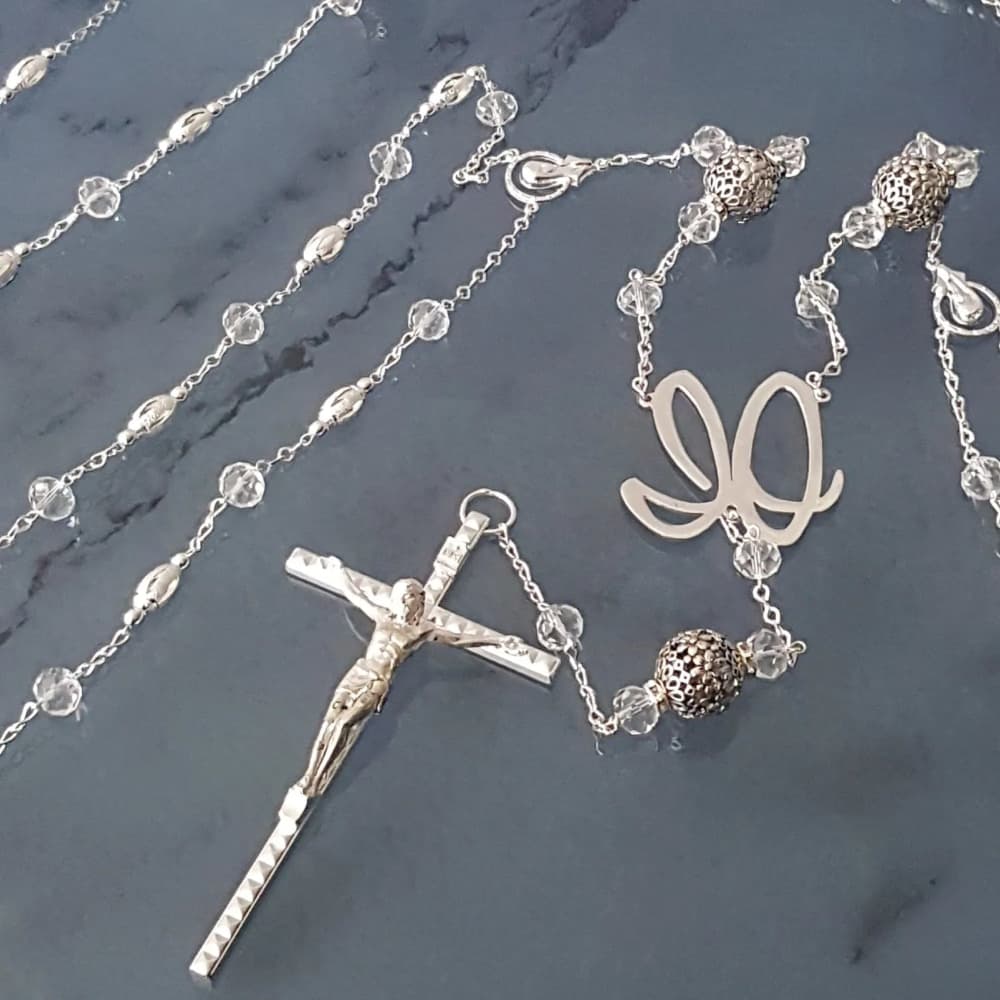 Lazo de boda plateado con cuentas de estilo europeo y cruz italiana detallada, accesorio artesanal para ceremonias nupciales religiosas.