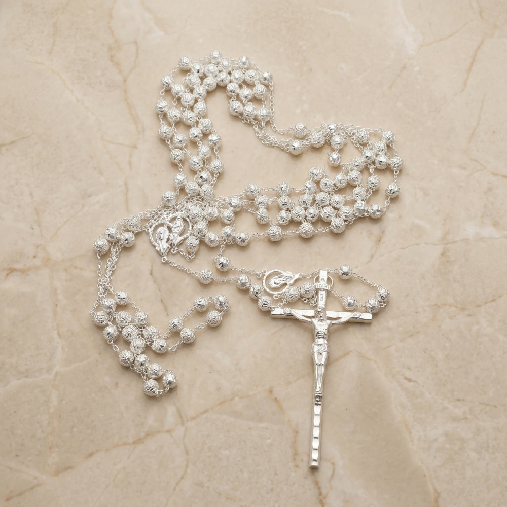 lazo de boda plateado con cuentas en forma de rosa con un crucifijo de plata con relieve.