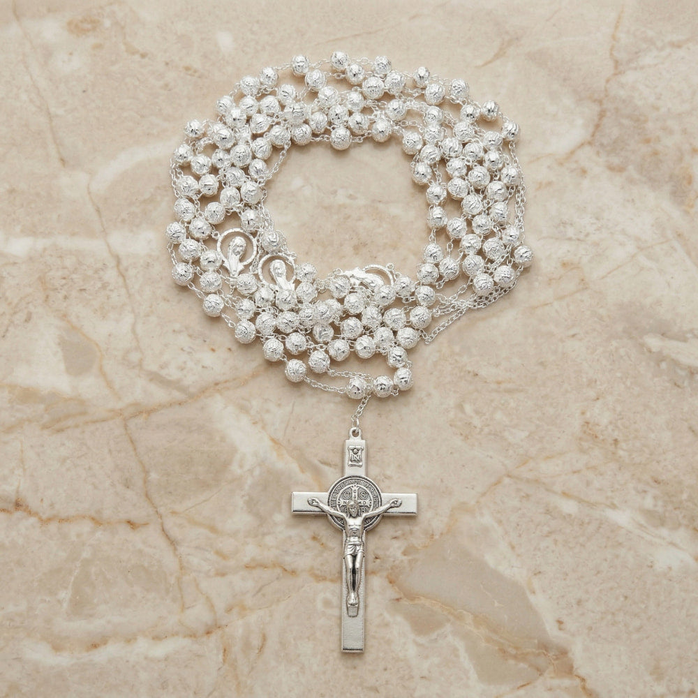 Lazo de boda plateado con cuentas texturizadas, medallas religiosas y cruz italiana de San Benito para ceremonias nupciales.