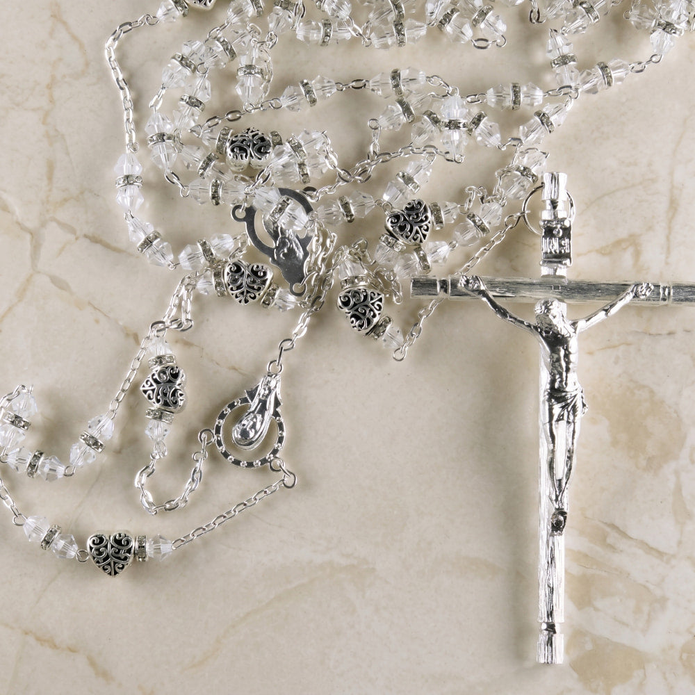 Lazo de boda con cuentas de cristal, separadores de corazón en filigrana plateada y crucifijo, ideal para ceremonias nupciales elegantes.