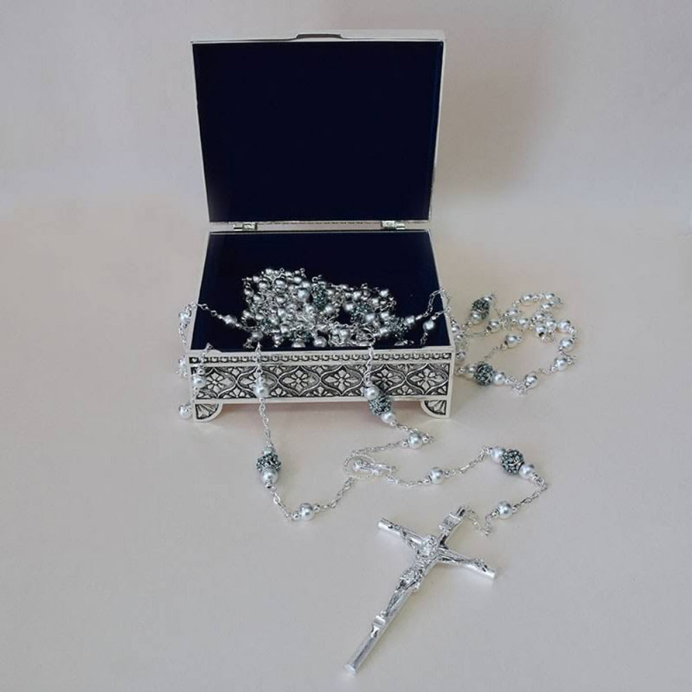 Lazo de boda matrimonial con cuentas plateadas y crucifijo ornamentado, incluye estuche metálico grabado de lujo, accesorio esencial para ceremonias religiosas.