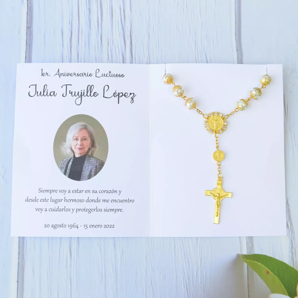 Decenario en tono dorado con cuentas tipo perla y tarjeta personalizada, ideal como recuerdo para aniversario luctuoso.