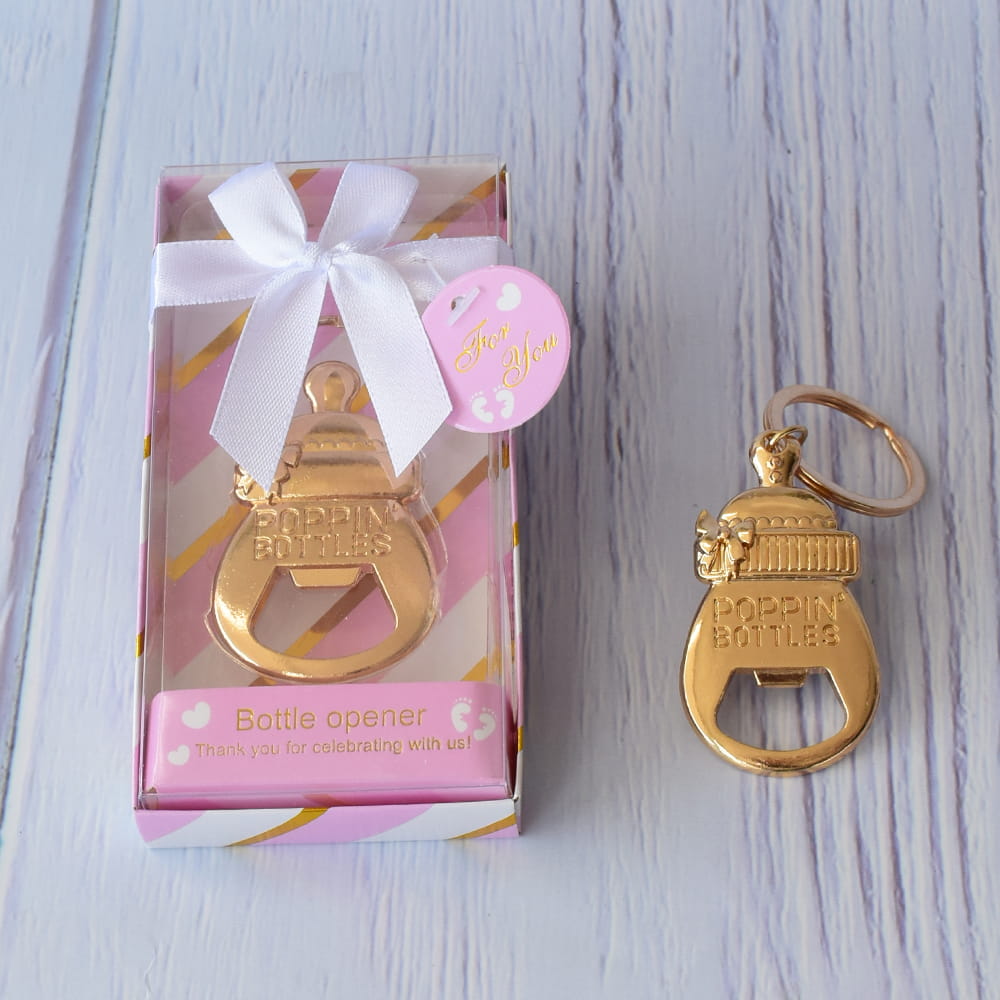 Destapador dorado en forma de biberón en caja decorativa rosa a rayas con moño blanco, ideal para recuerdo de baby shower.