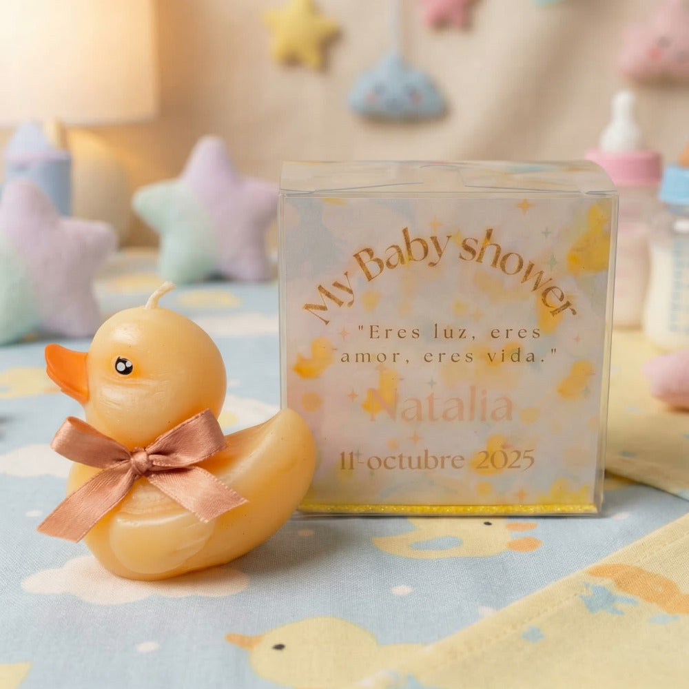 Vela artesanal en forma de patito con moño, presentada en caja transparente personalizada, ideal como recuerdo para baby shower.