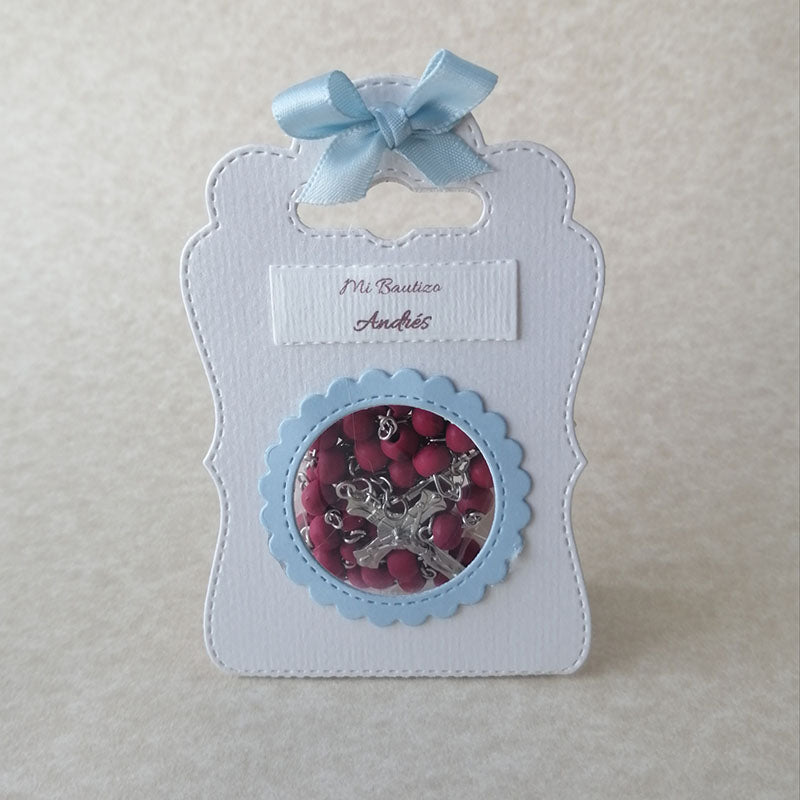Rosario de madera de palo de rosa con cuentas rojas y crucifijo plateado, ideal como recuerdo para eventos religiosos.