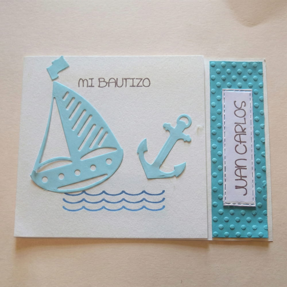 Tarjeta de invitación o recuerdo para bautizo con temática de marinero, decorada con figuras de barquito y ancla en relieve y nombre personalizado.