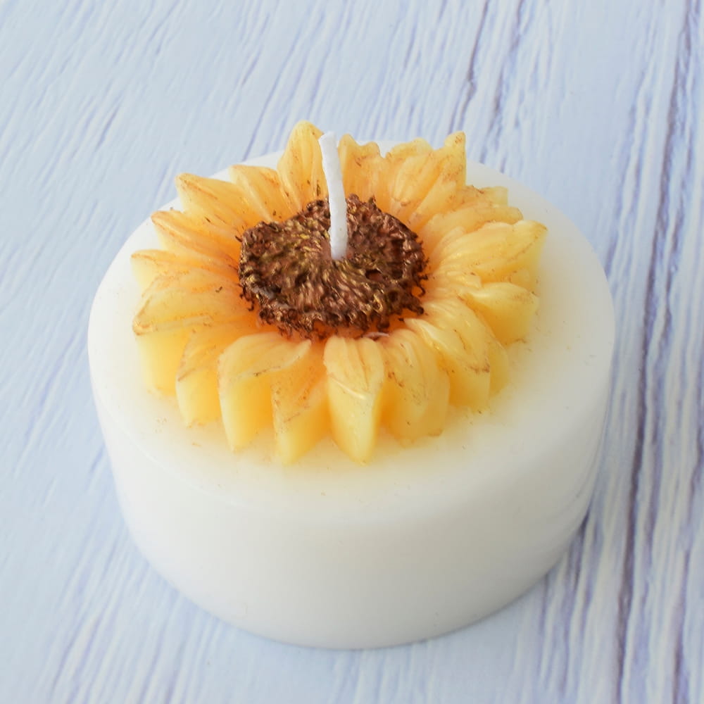 Vela artesanal blanca con figura de girasol amarillo para recuerdos de XV años.