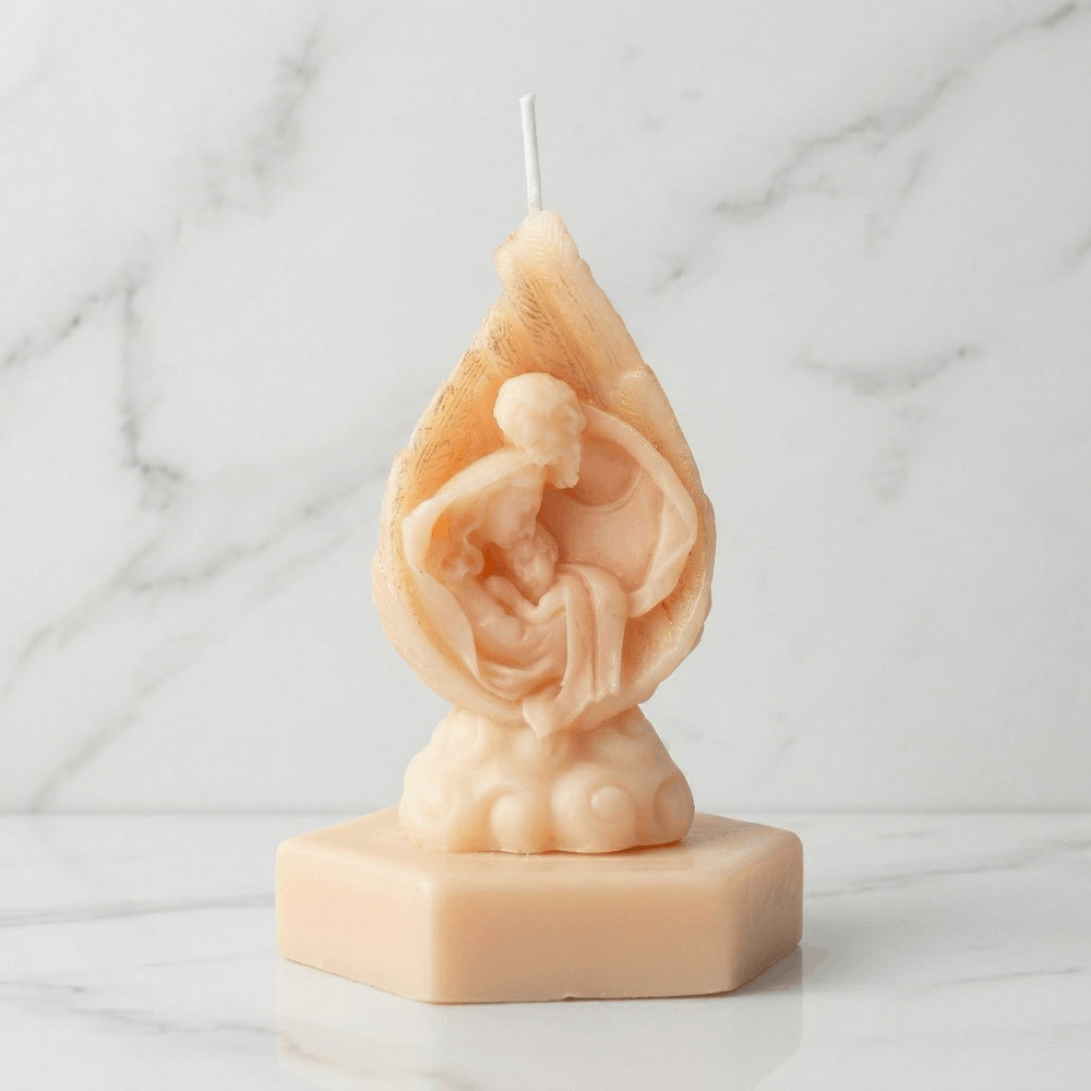 Vela artesanal en forma de flama con la Sagrada Familia en relieve, ideal como recuerdo religioso para eventos sociales.