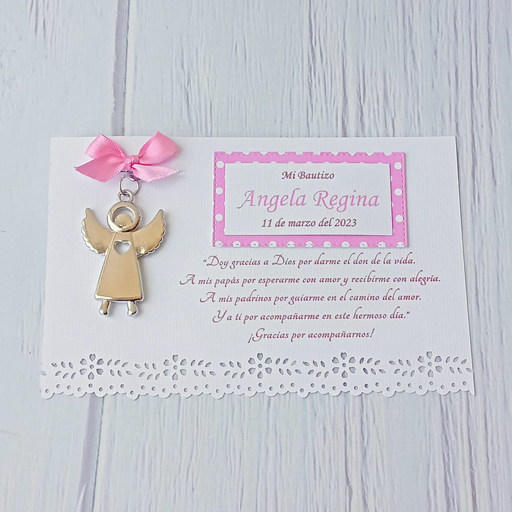Recuerdo de bautizo para niña. Llavero metálico en forma de ángel con un pequeño moño de listón rosa, montado sobre una tarjeta blanca personalizada con detalles punteados en rosa, el nombre de la festejada, fecha y una oración de agradecimiento