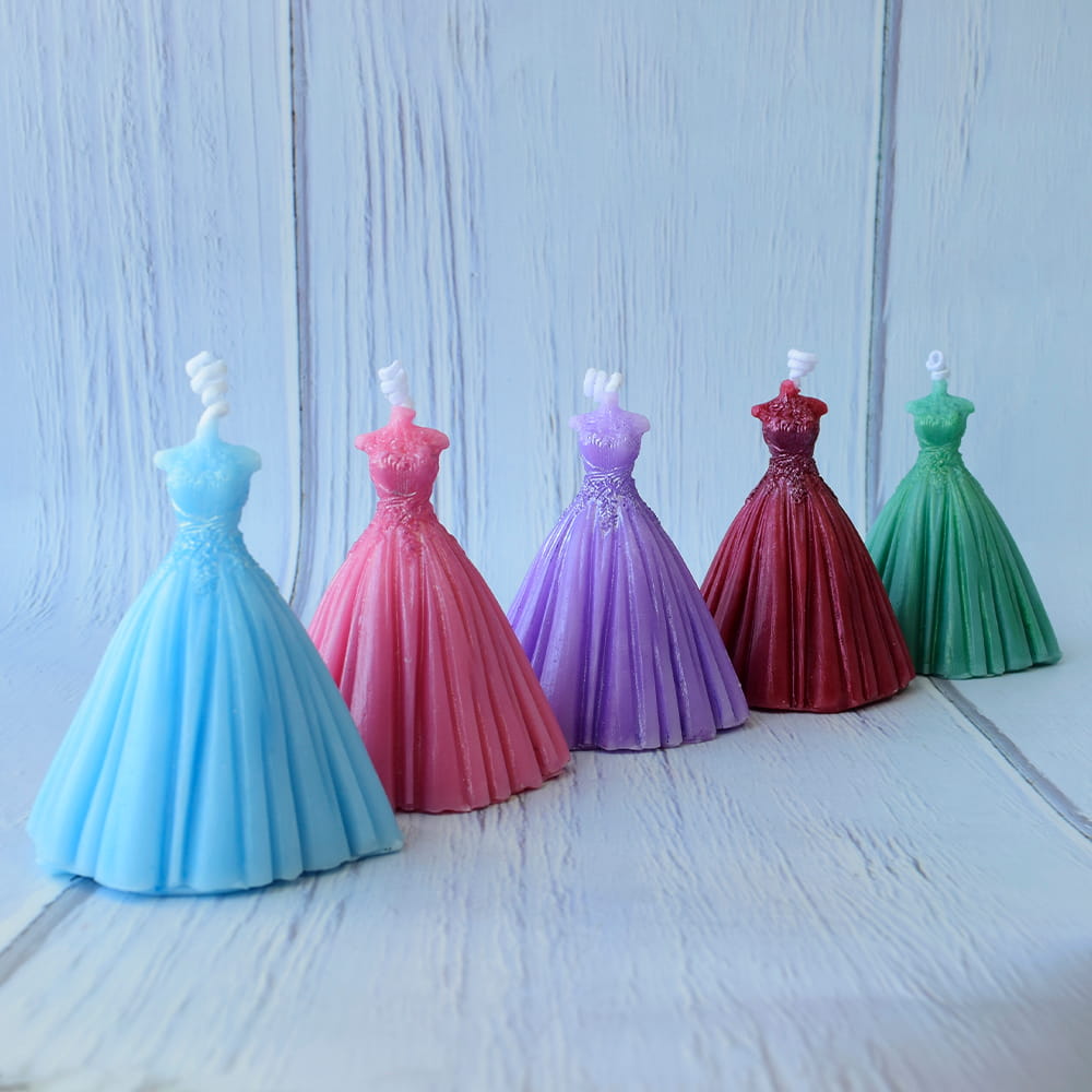 Recuerdos para quinceañera de velas pequeñas en forma de vestido en diferentes colores.