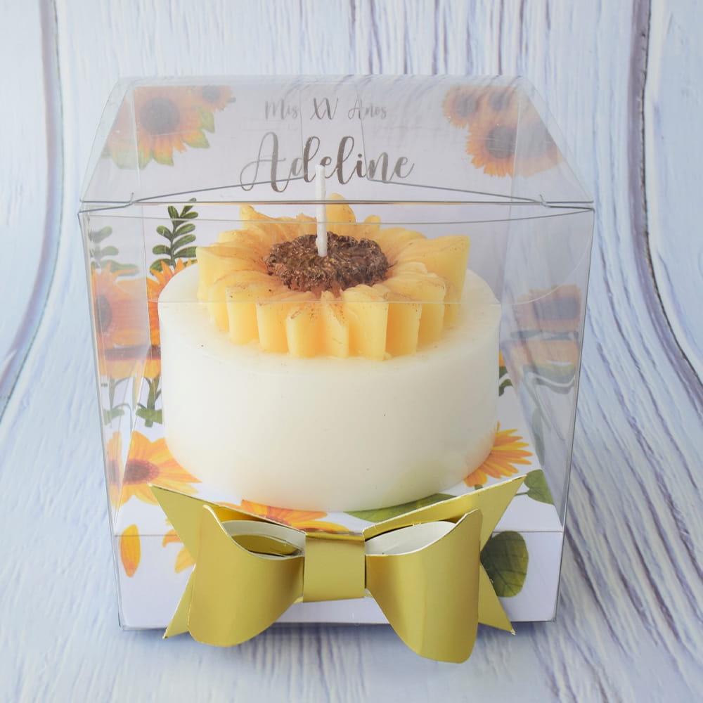 Recuerdo de XV años de vela en forma de girasol en caja transparente personalizada.