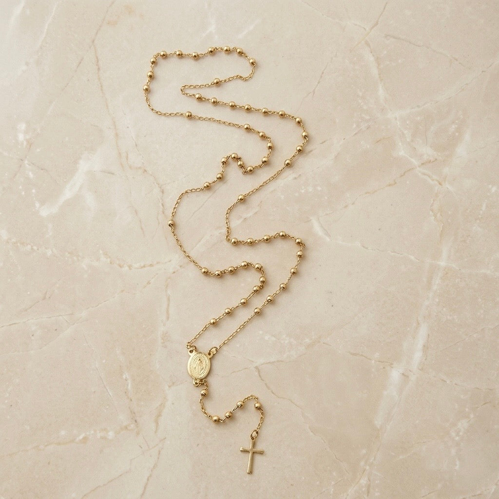 Rosario dorado con medalla de cristo y cruz dorada.