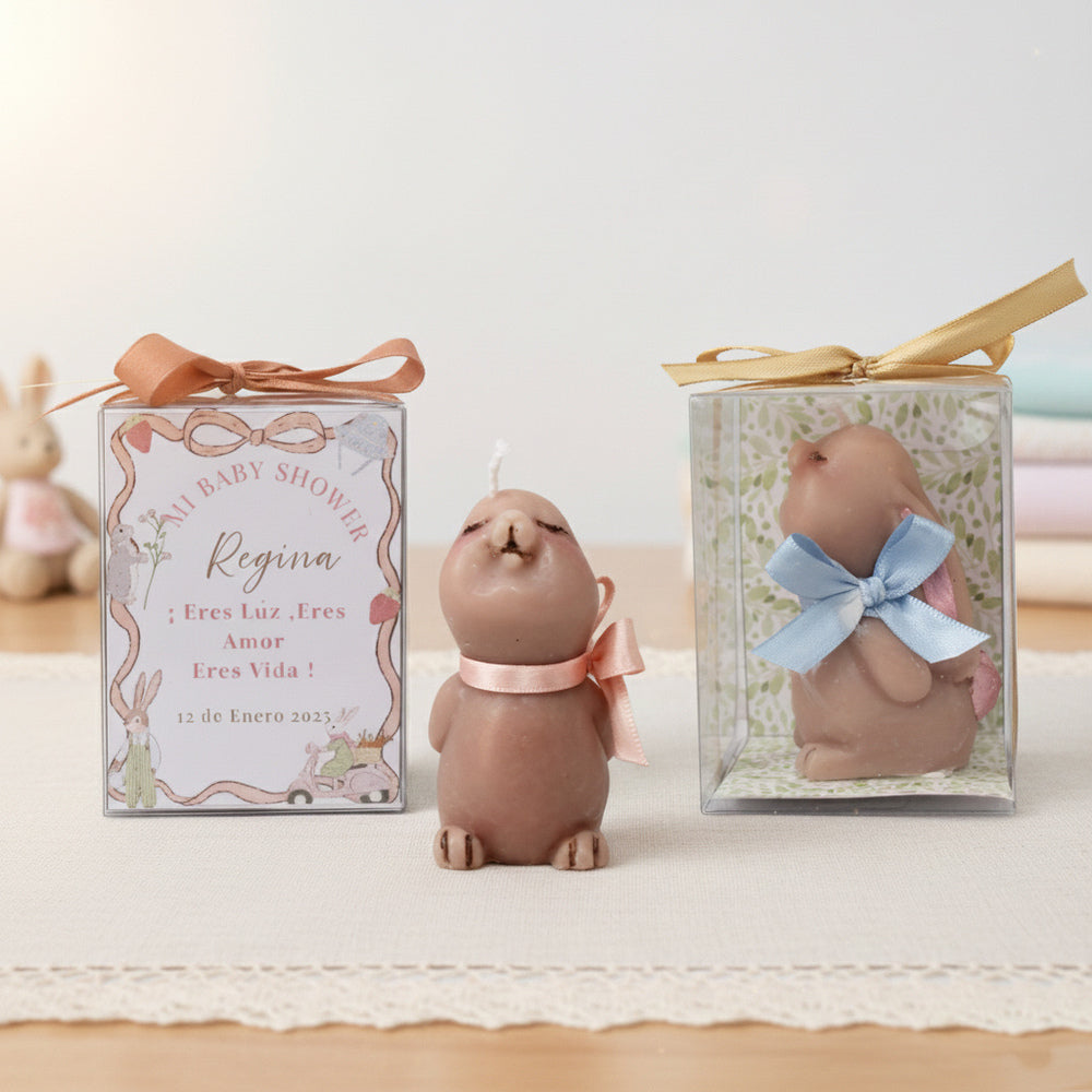 Vela artesanal en forma de conejo para baby shower o bautizo, presentada en caja decorada con listón y etiqueta personalizada.
