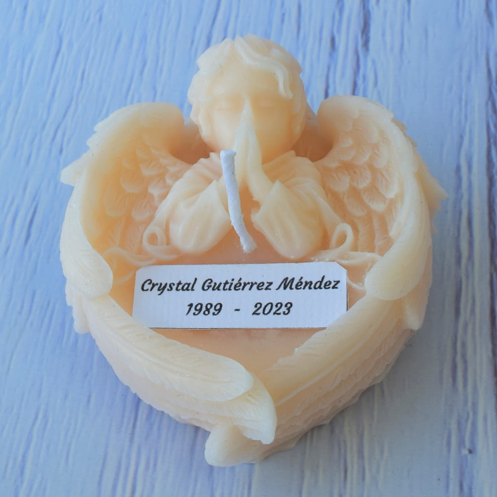 Vela blanca artesanal en forma de ángel orando, ideal como recuerdo personalizado para eventos religiosos y ceremonias luctuosas.