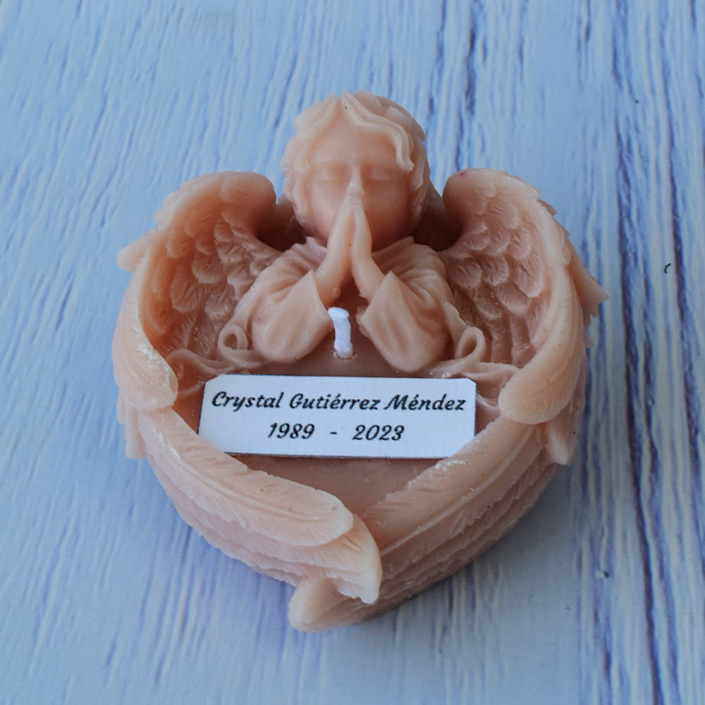 Vela blanca artesanal en forma de ángel orando, ideal como recuerdo personalizado para eventos religiosos y ceremonias luctuosas.