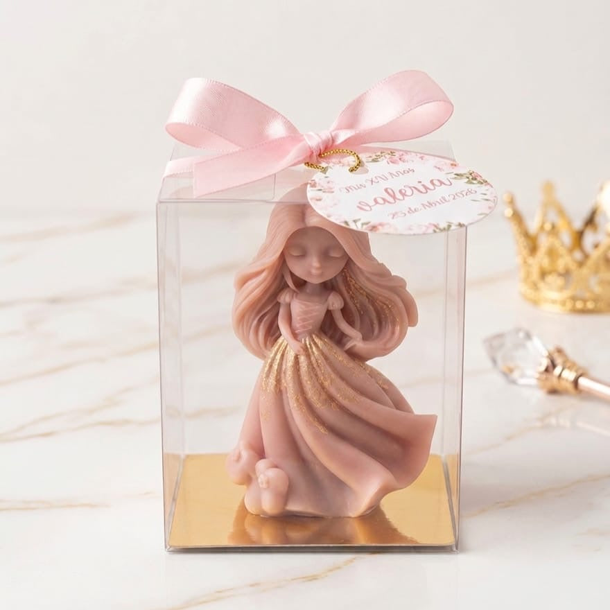 Vela decorativa de princesa rosa con dorado, en caja transparente con moño y etiqueta personalizada. Un elegante souvenir de quinceañera.